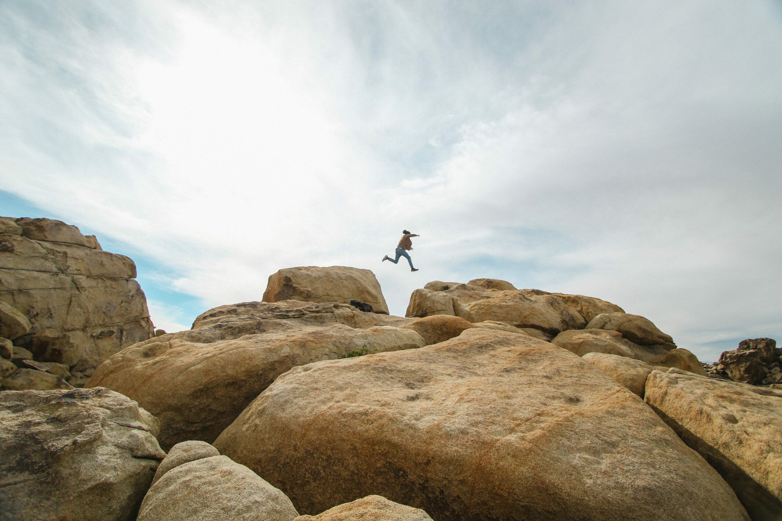 Person jumping from one rock to another