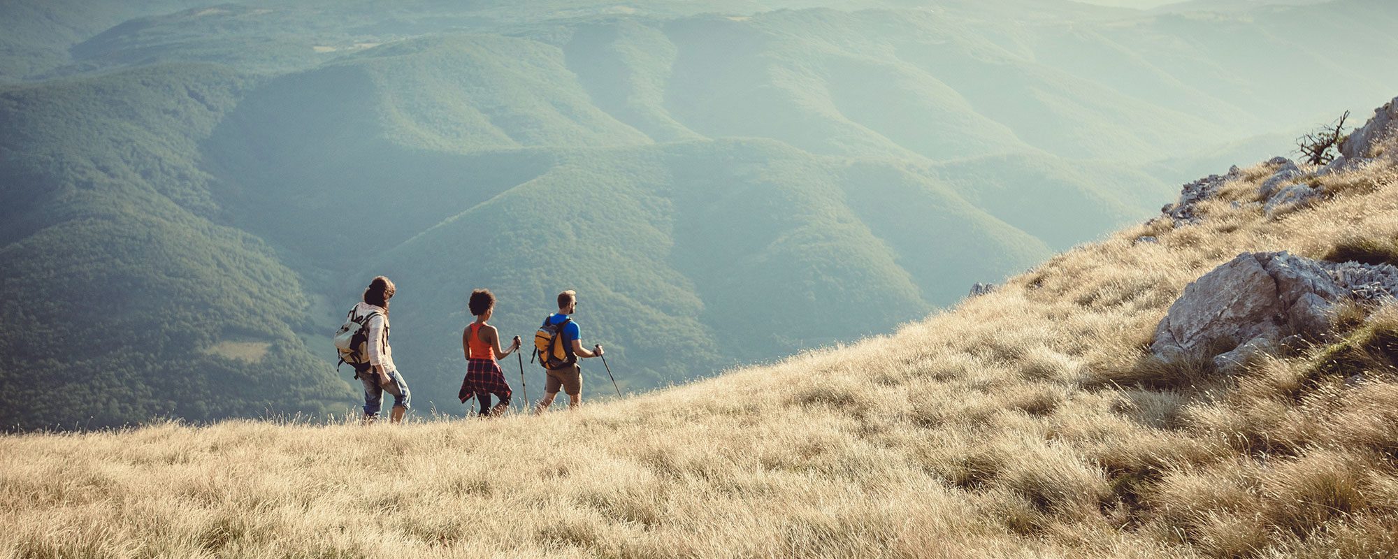 three people hiking on a mountain