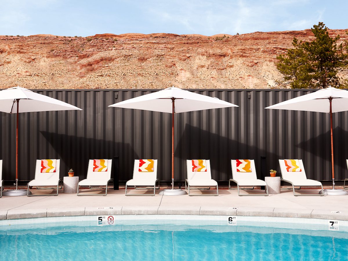 A pool area with seating and a parasol